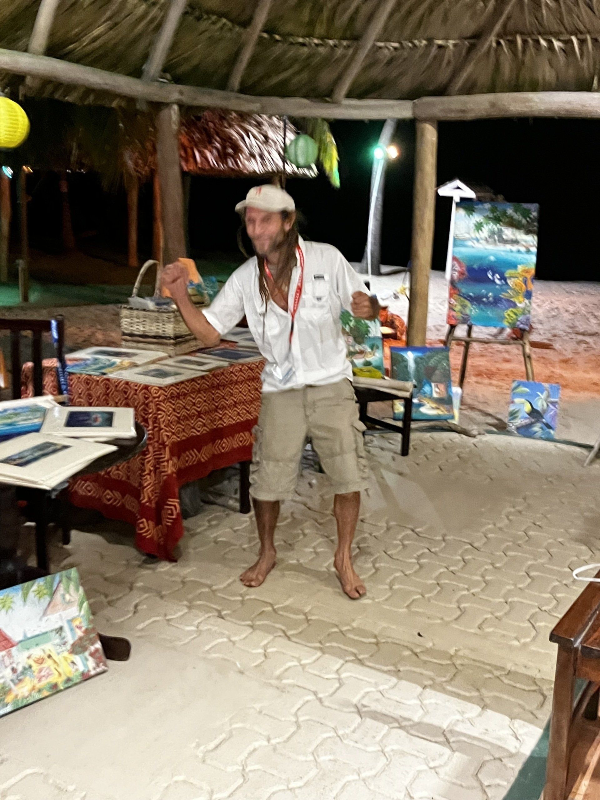 A man is standing in front of a table with a painting on it.