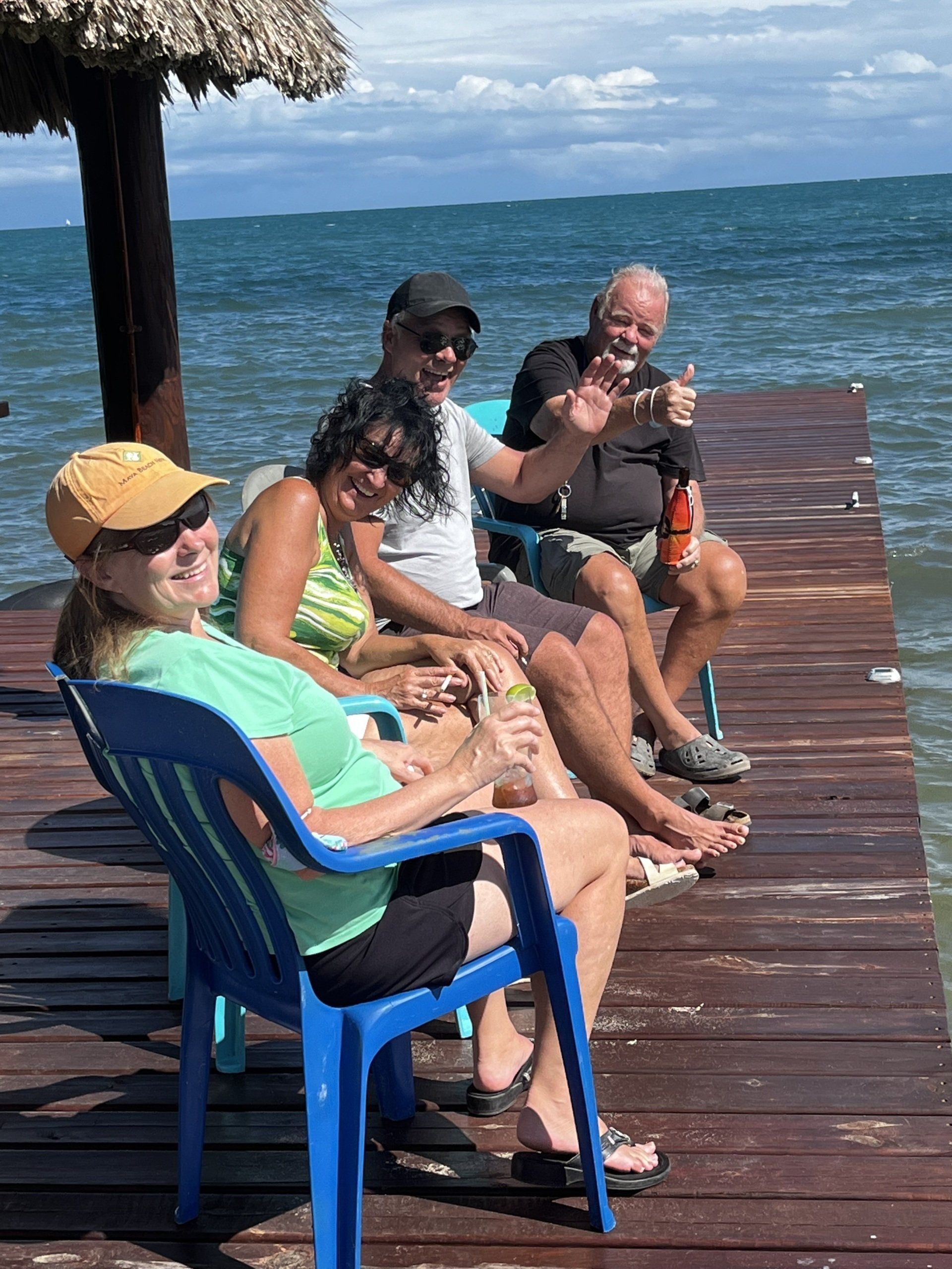 A group of people are sitting on a dock near the ocean.