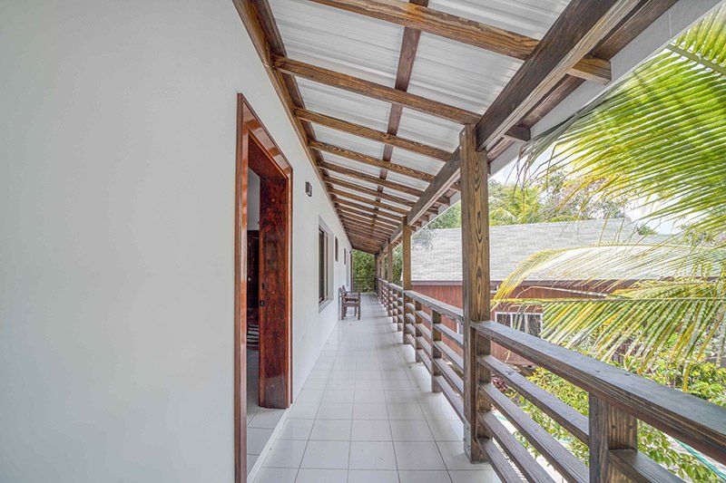 A long hallway with a wooden railing leading to a balcony.