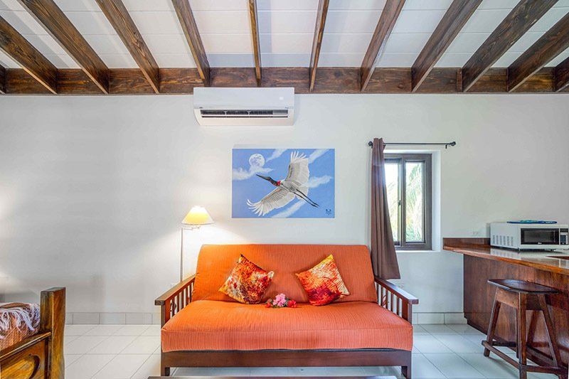 A living room with a couch and a painting on the wall.