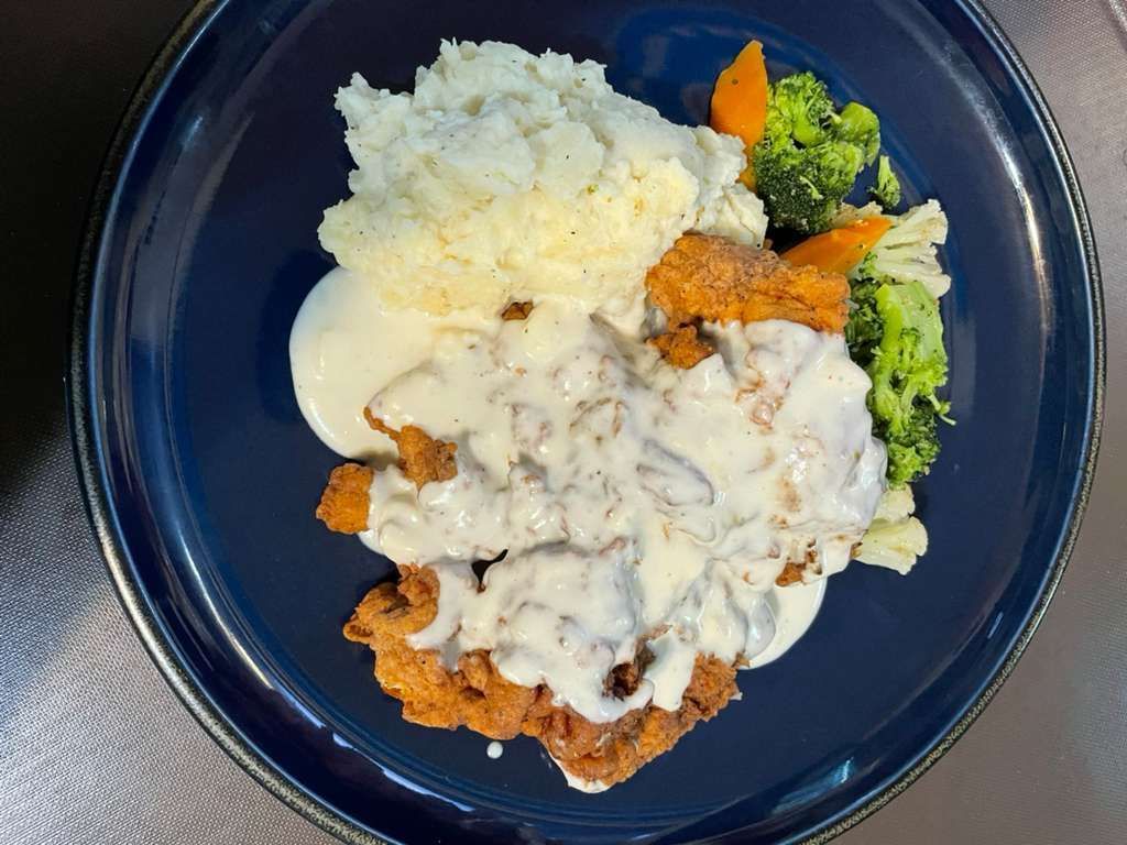 A white plate topped with lobsters and vegetables.