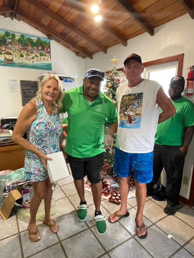 A group of people are posing for a picture under a thatched roof.