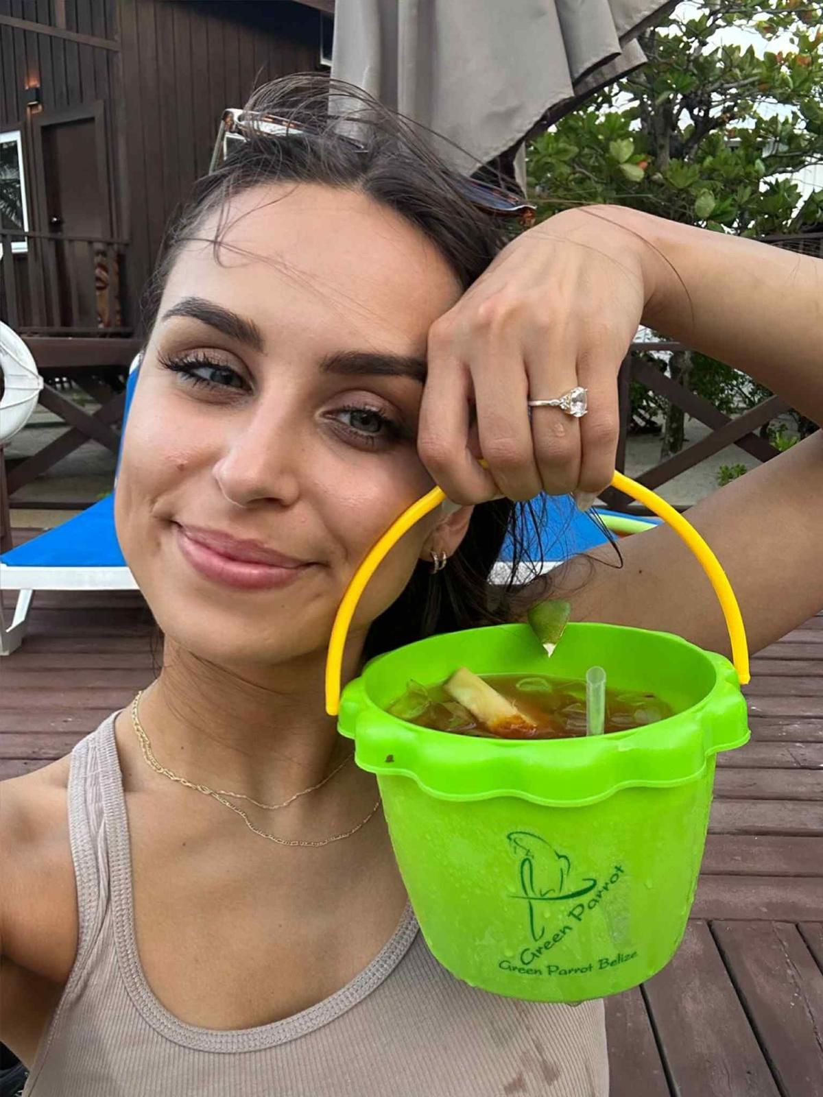 A man in a white shirt is holding a drink at a bar