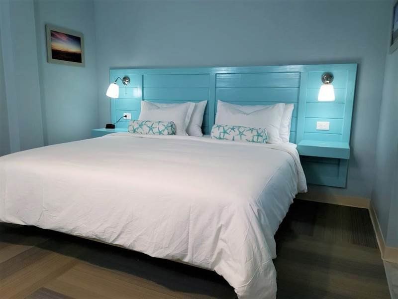 A hotel room with a large bed and blue walls
