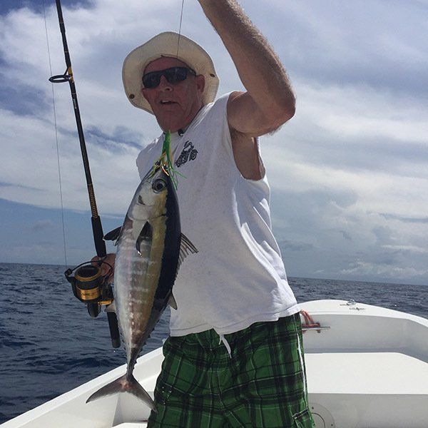 A man on a boat holding a fish in his hand