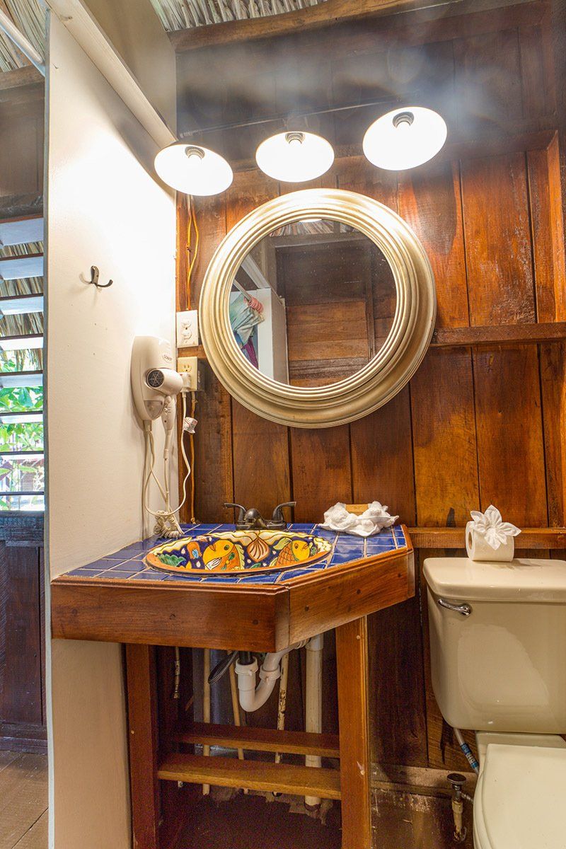 A bathroom with a sink , toilet and mirror.