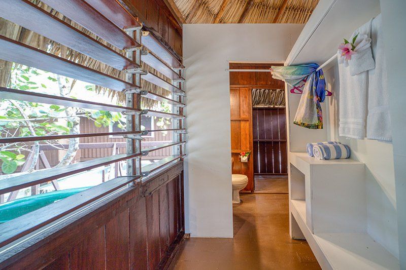 A bathroom with a toilet , sink , and window.