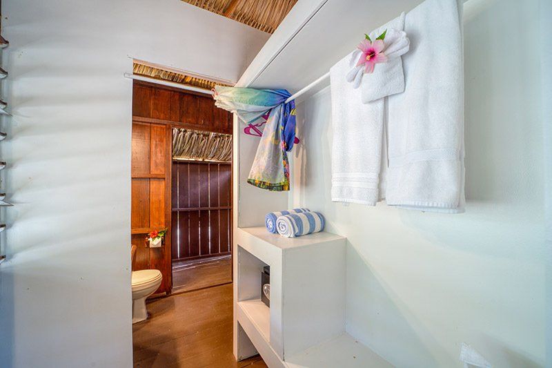 A bathroom with towels hanging on the wall and a toilet.