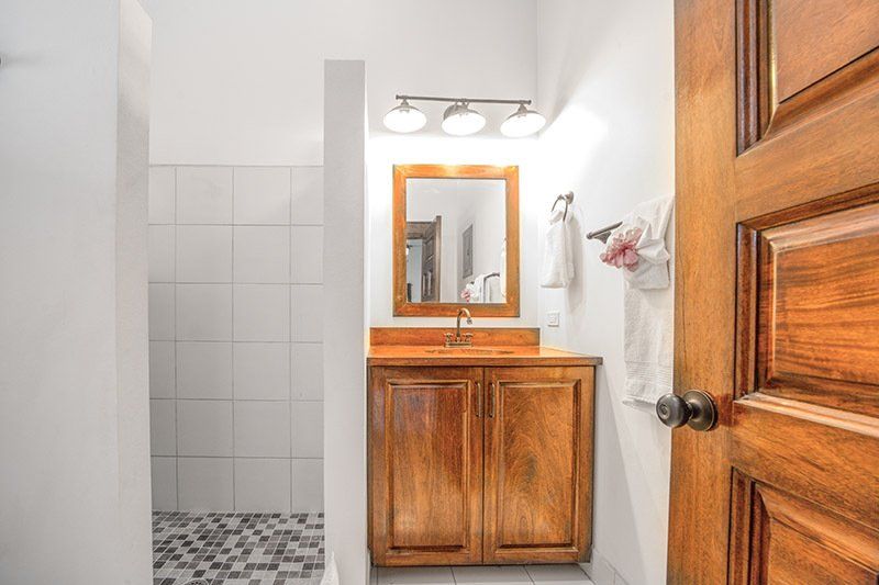 A bathroom with a sink , mirror and shower.