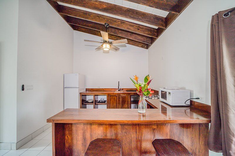 A kitchen with a refrigerator , microwave , and a ceiling fan.