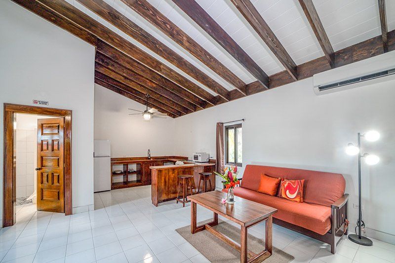A living room with a couch , coffee table , and kitchen.