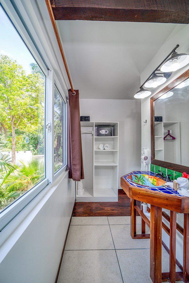 A bathroom with a sink , mirror and closet.