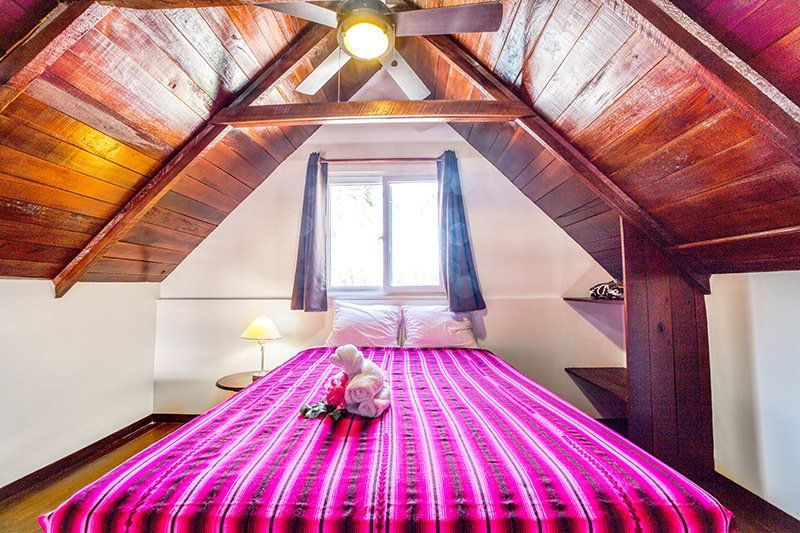 A bedroom with a bed and a ceiling fan