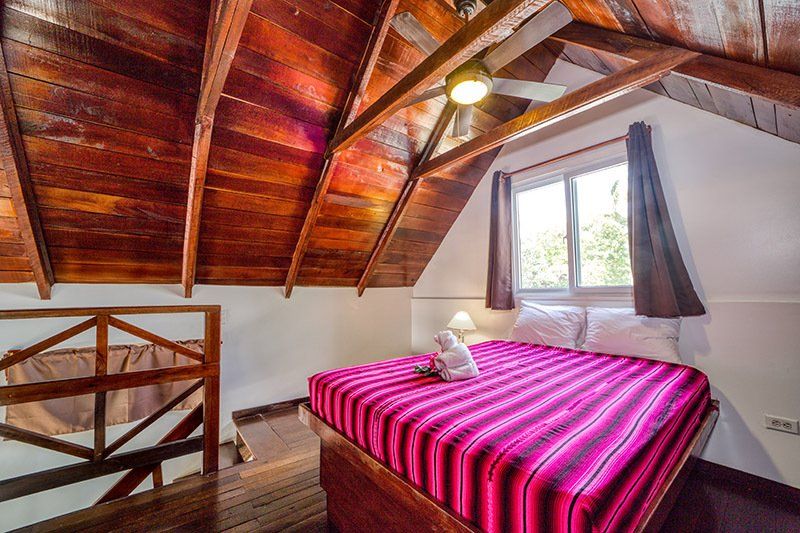 A bedroom with a king size bed and a wooden ceiling.