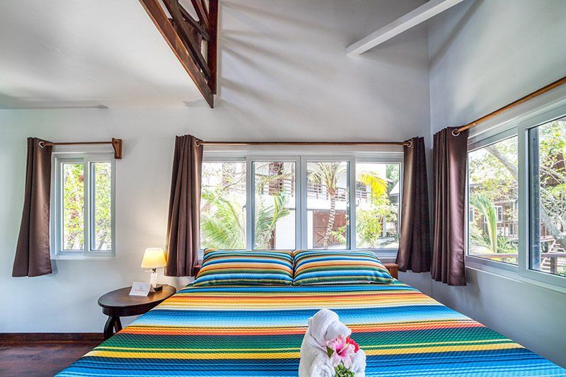 There is a bed with a colorful blanket in the middle of the room.