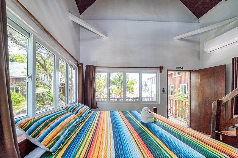 There is a bed with a colorful blanket in the middle of the room.