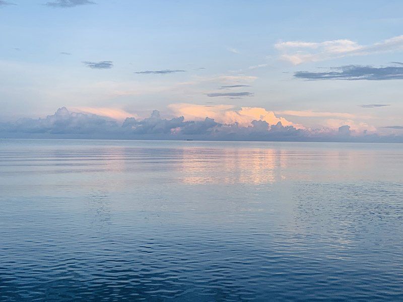 A large body of water with a cloudy sky in the background