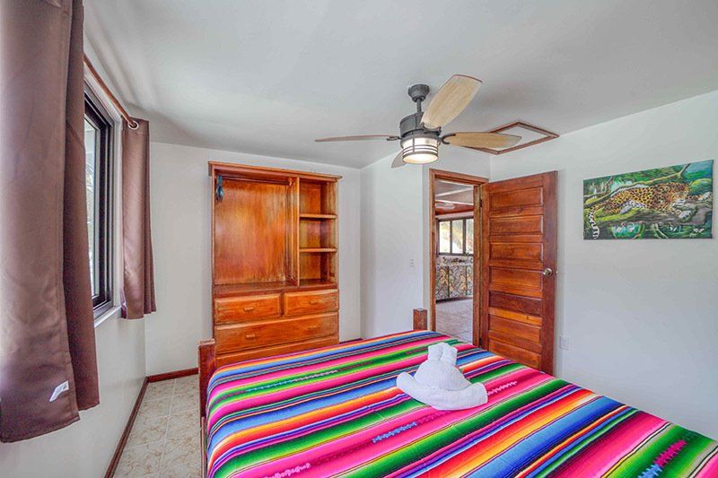 A bedroom with a bed and a ceiling fan.