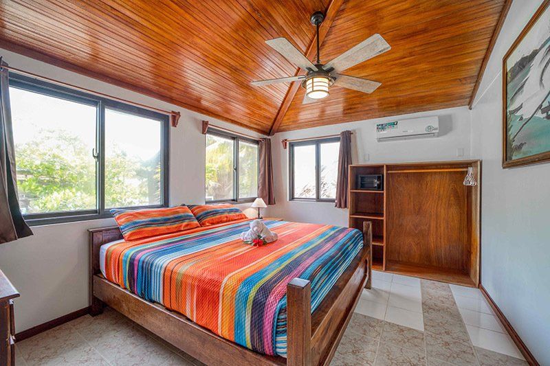 A bedroom with a king size bed and a ceiling fan.