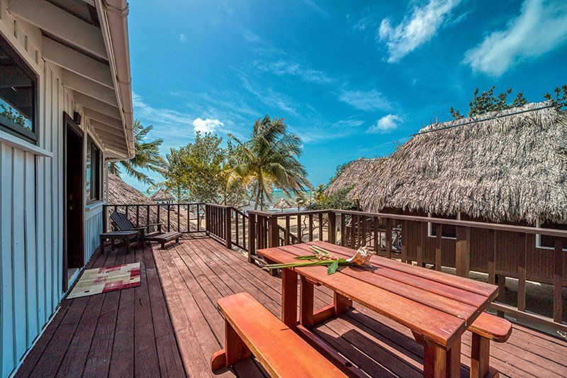 A wooden deck with a picnic table and benches on it.