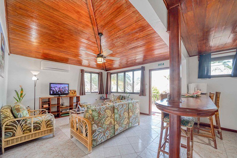 A living room with a couch , chairs , a table and a television.