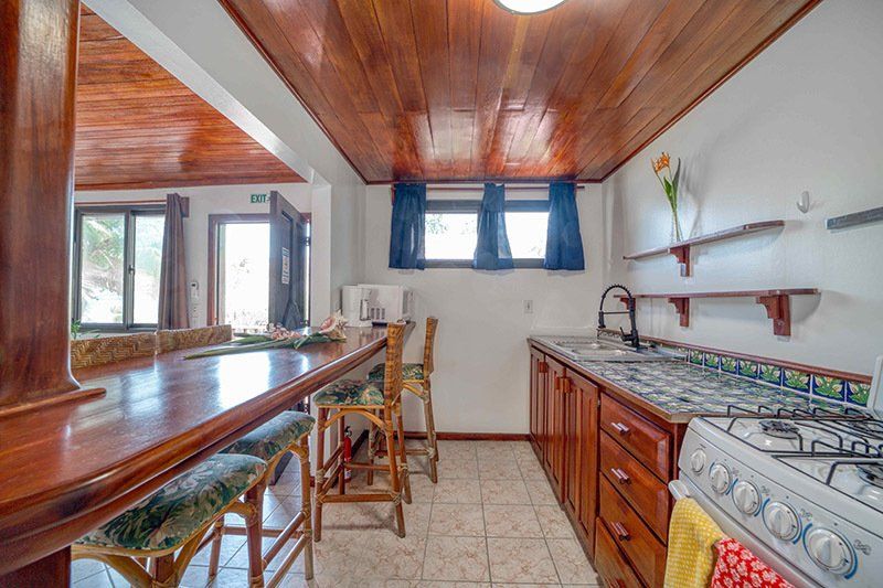 A kitchen with a stove , sink , table and chairs.