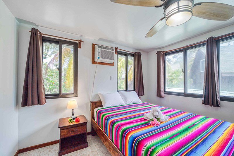 A bedroom with a bed , nightstand , and ceiling fan.