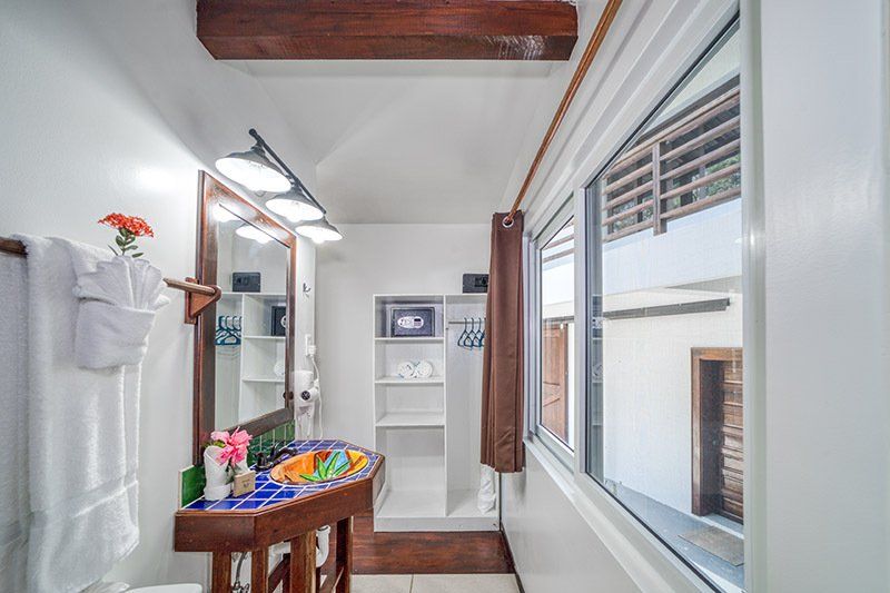 A bathroom with a sink , mirror , and window.
