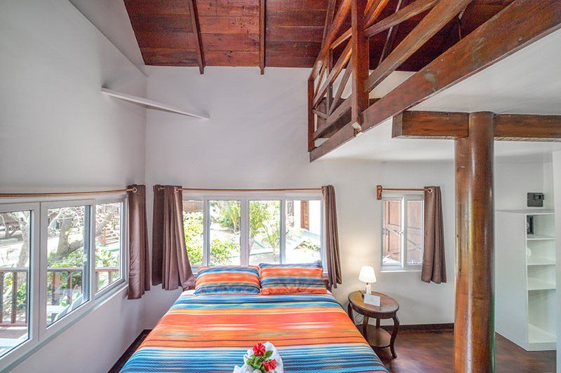 A bedroom with a bed , a table , and a balcony.