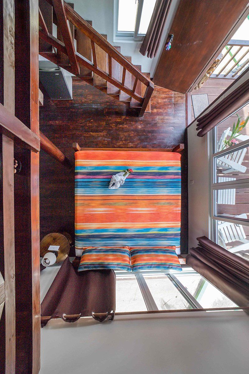 An aerial view of a bedroom with a bed and stairs.