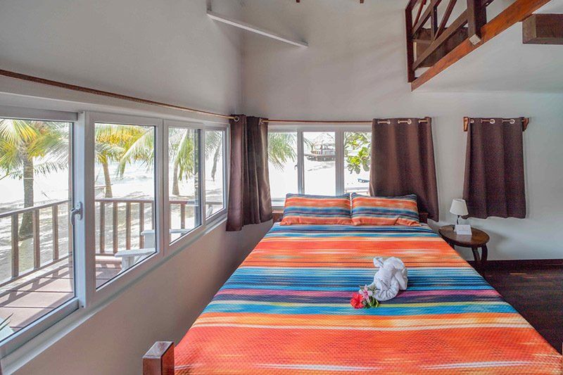 There is a bed with a colorful blanket in the middle of the room.