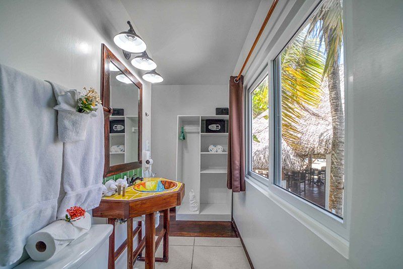 A bathroom with a sink , mirror and window.