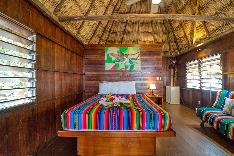 There is a bed with a colorful blanket in the middle of the room.