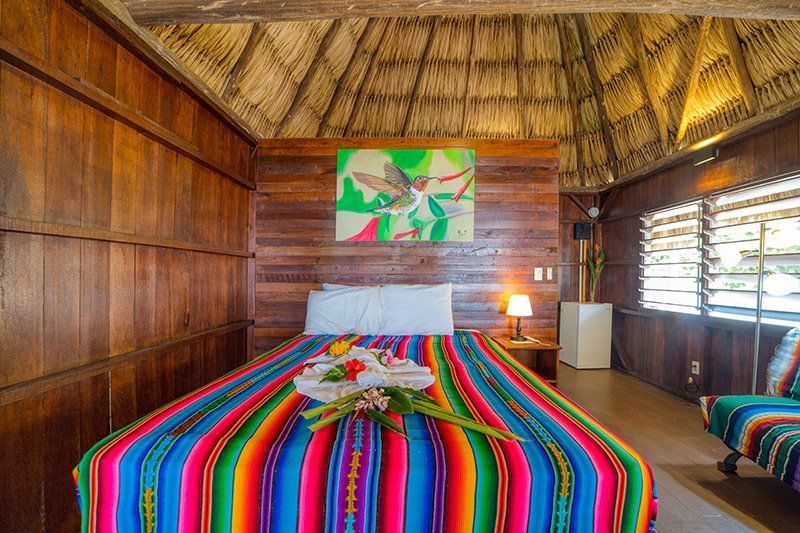 There is a bed with a colorful blanket on it in the room.