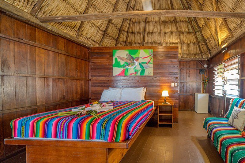 There is a bed with a colorful blanket in the middle of the room.