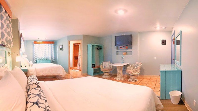 A hotel room with two beds , a table and chairs.