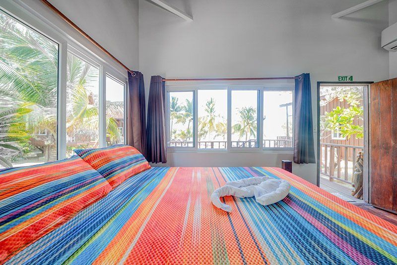 A bedroom with a king size bed and lots of windows.