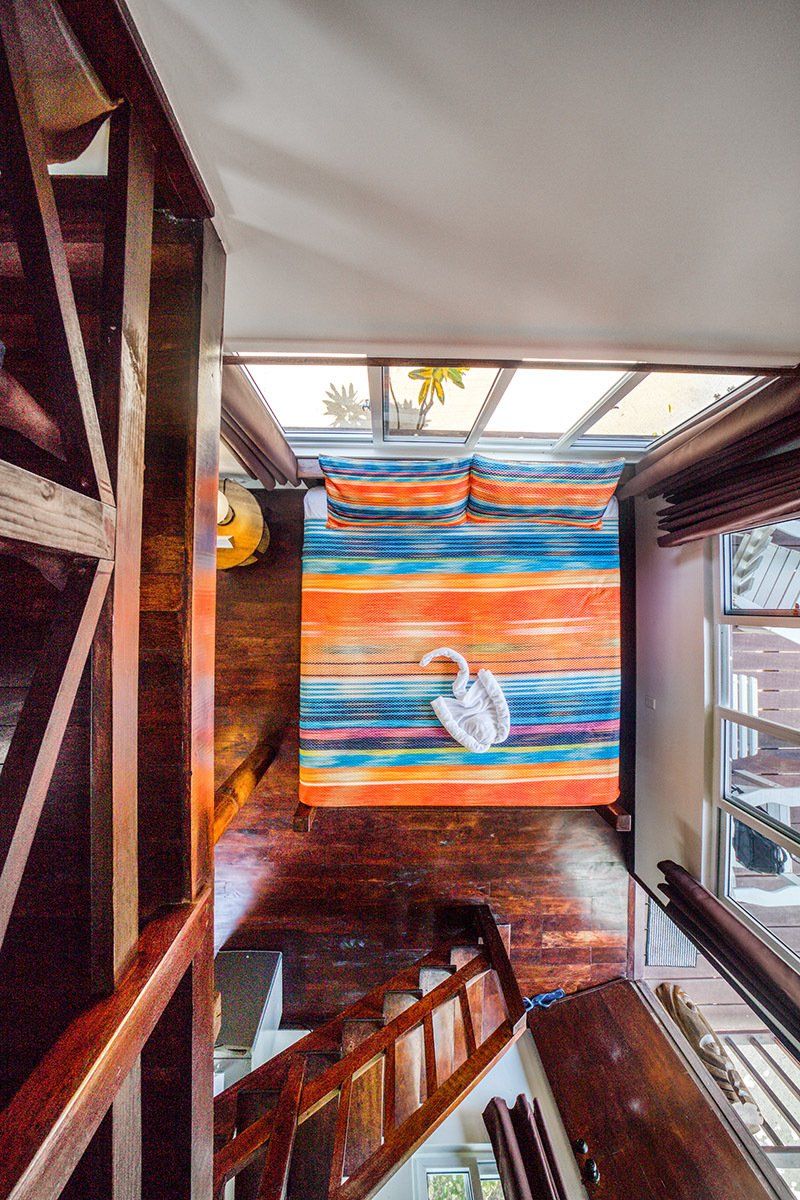 An aerial view of a bedroom with a bed and stairs.