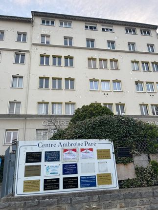 Un grand bâtiment blanc avec une pancarte devant qui dit centre ambreive pore