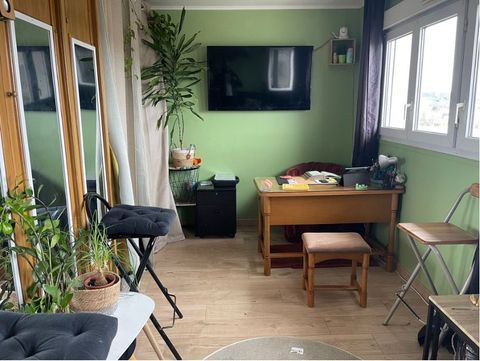 Une pièce avec un bureau, des chaises, des miroirs et une télévision à écran plat au mur.