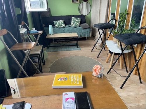 Un salon avec un canapé, une table, des chaises et un livre sur la table.