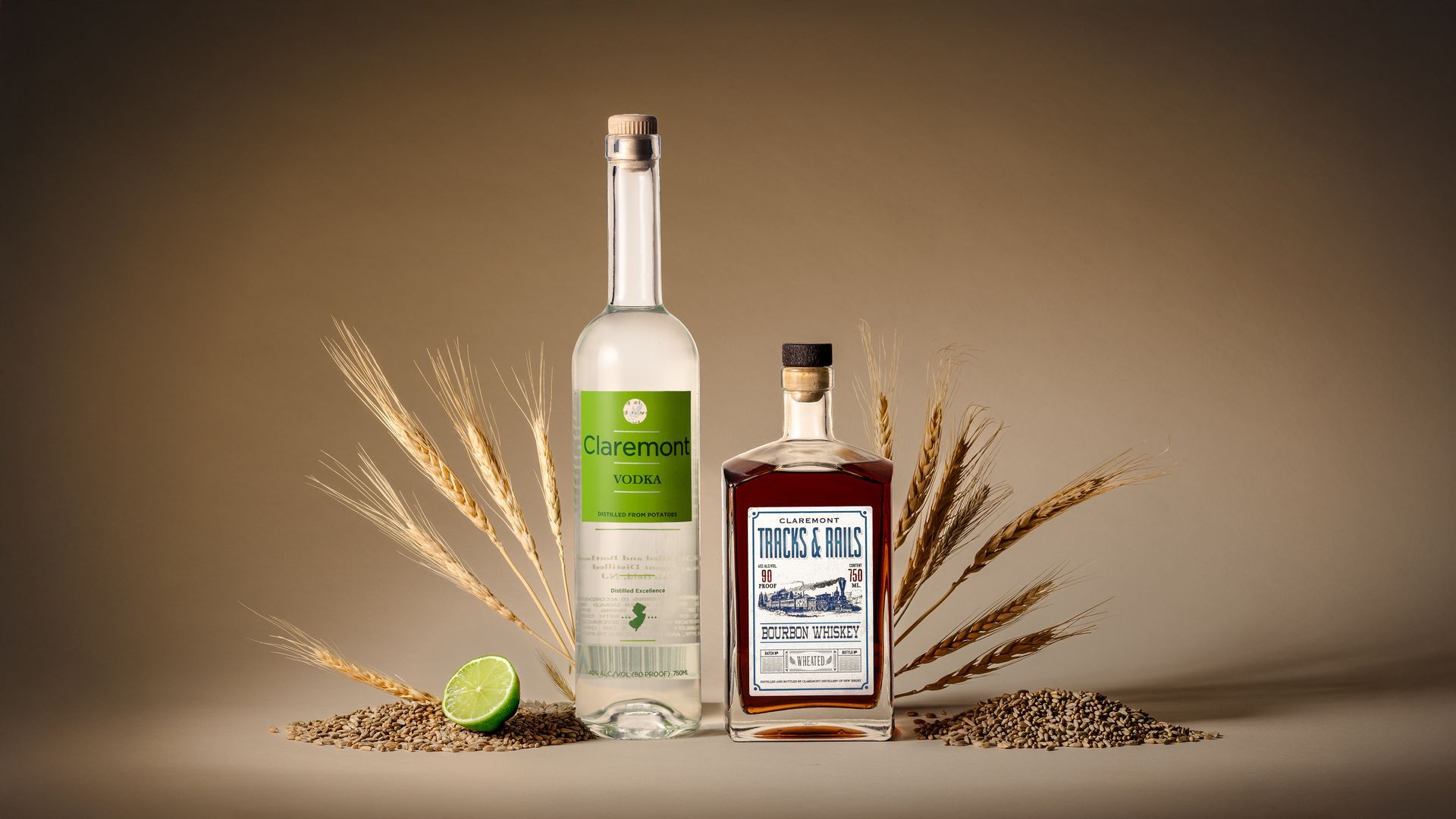 Two liquor bottles, lime wedge, wheat stalks, and grains against a tan background.