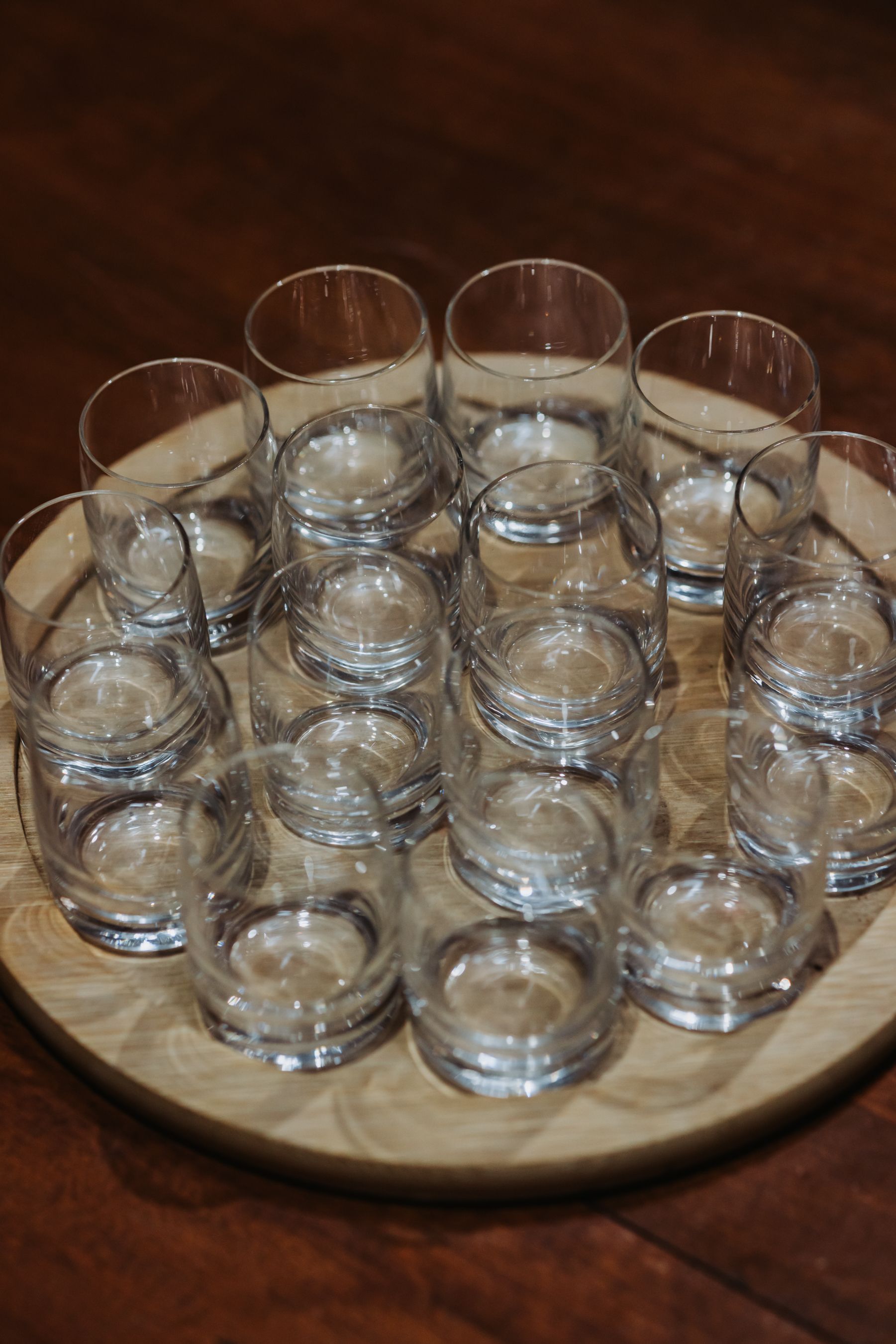 Clear glasses arranged on a wooden serving tray.