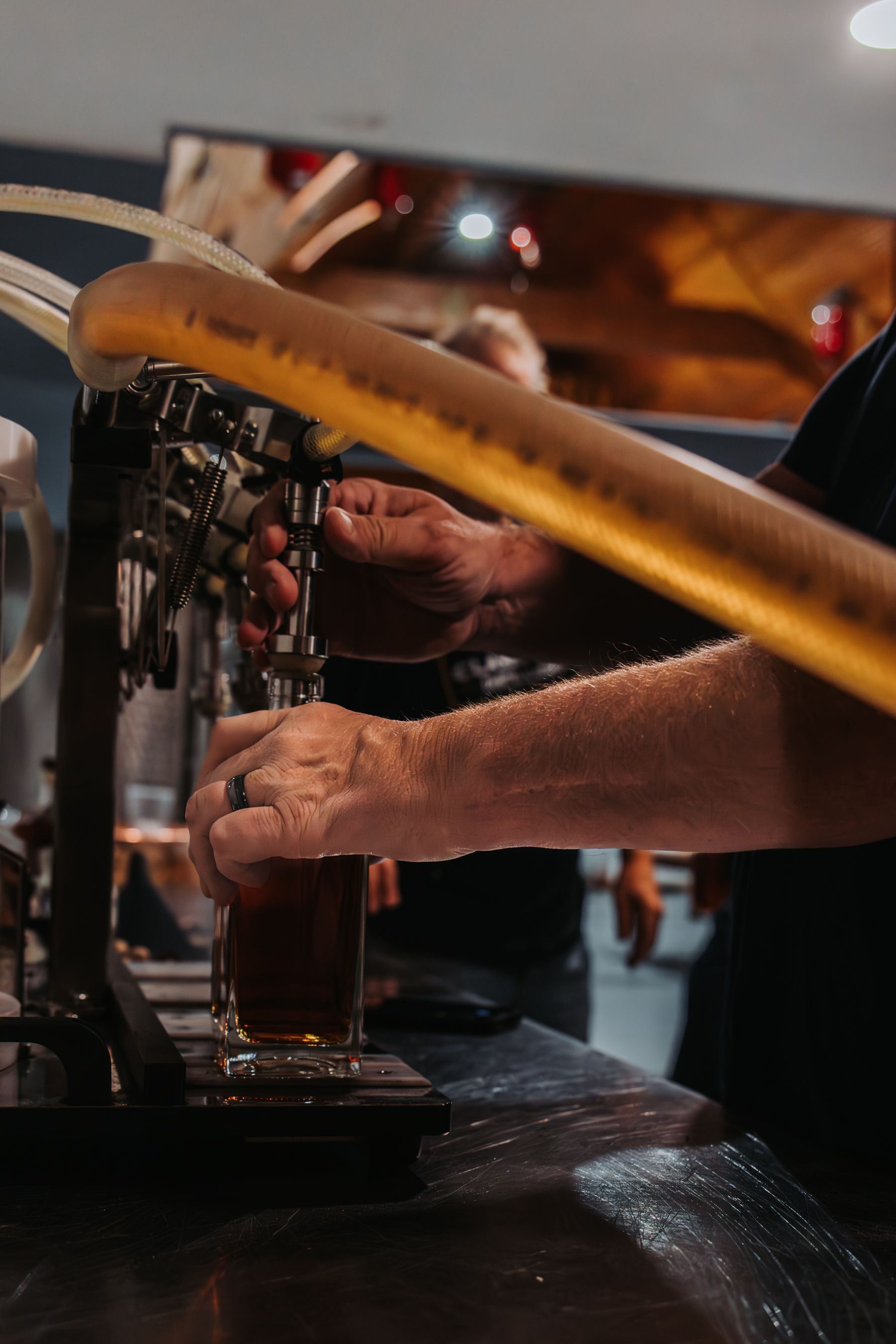 A person pouring beer from a tap into a glass at a bar.