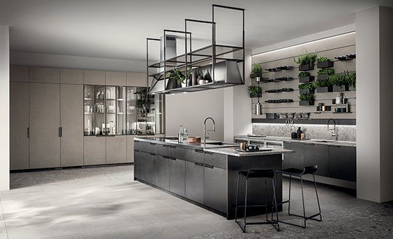 una cucina con armadi grigi ed elettrodomestici in acciaio inossidabile