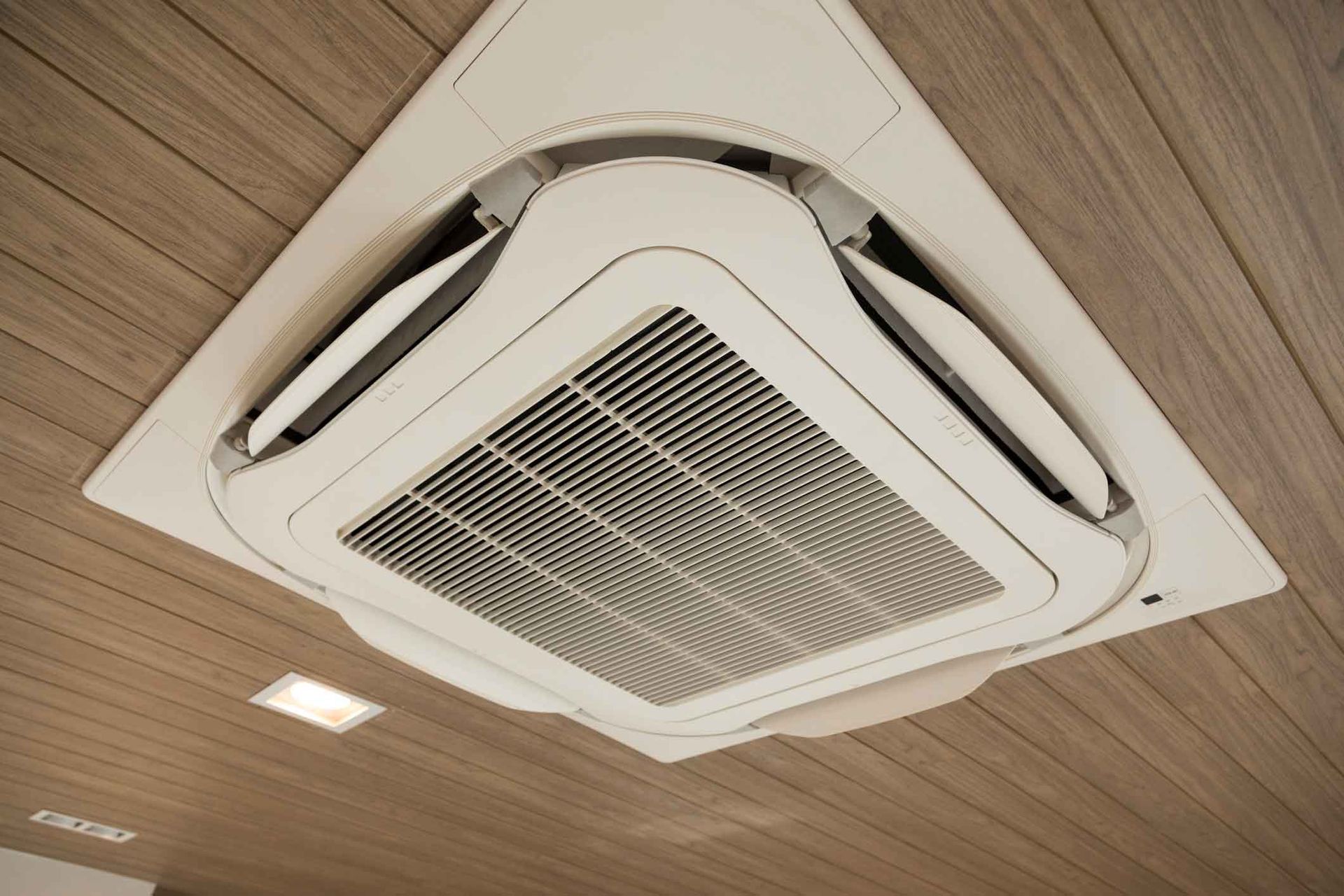 A White Air Conditioner Is Hanging From The Ceiling Of A Room – Sydney, NSW - Leumeah Air Conditioning