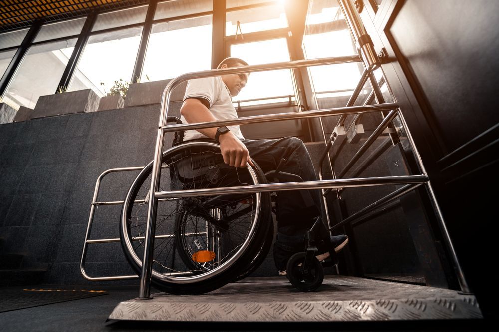 A man in a wheelchair is going up a set of stairs.