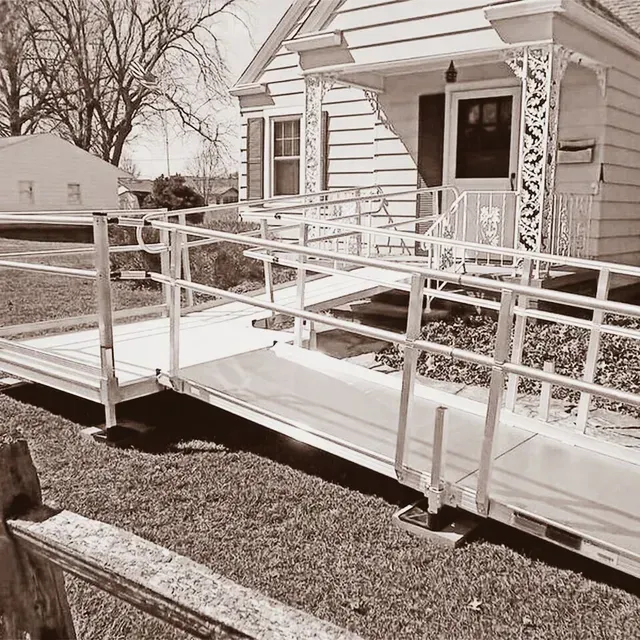 A black and white photo of a house with a ramp