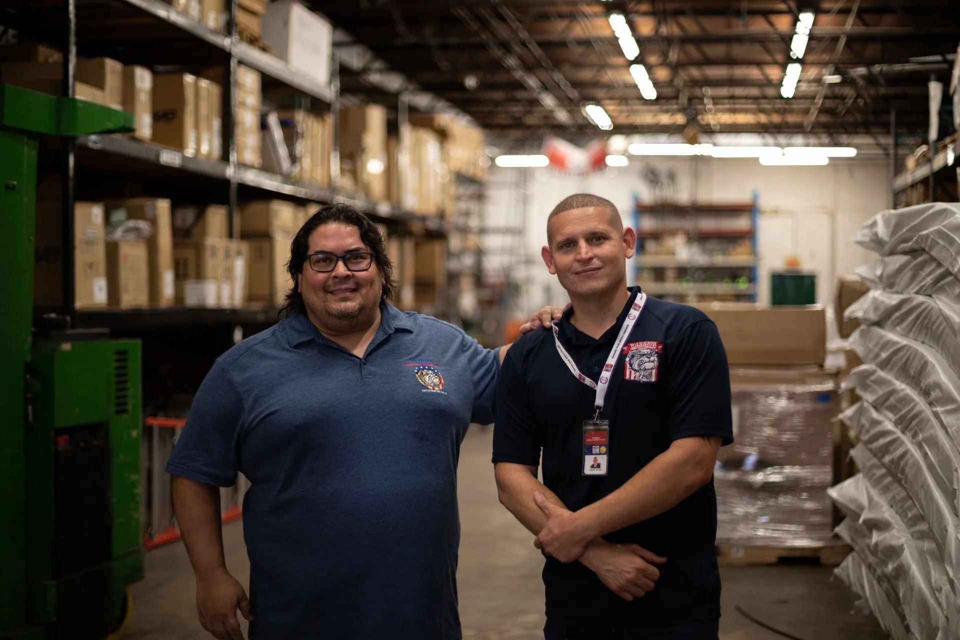 Two men are standing next to each other in a warehouse.