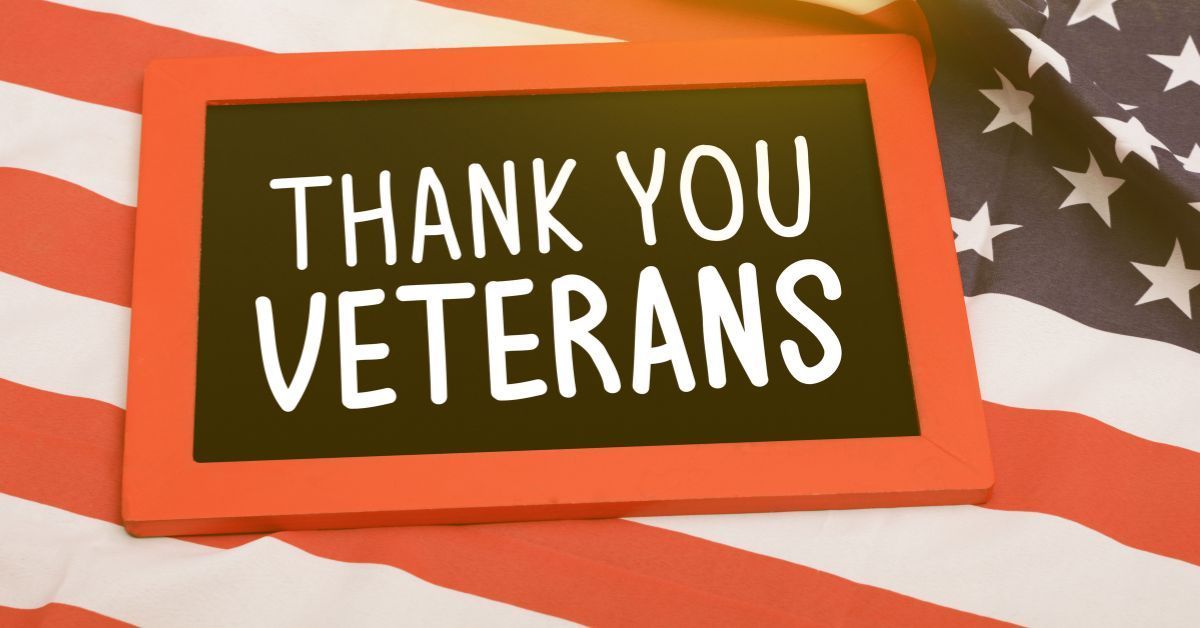 American flag background with bold text reading “Thank You Veterans” in honor of Veterans Day.
